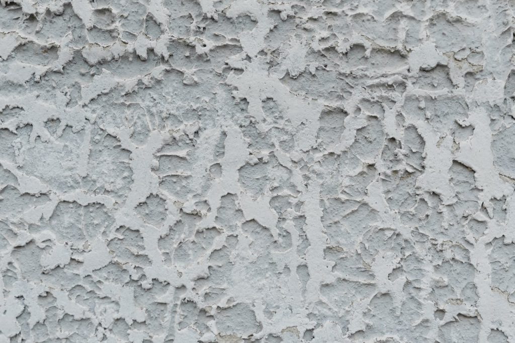 cracked-gray-stucco-wall-with-cracked-surface-6317433 Close-up of a textured stucco wall with weathered, rough patterns and grunge look.